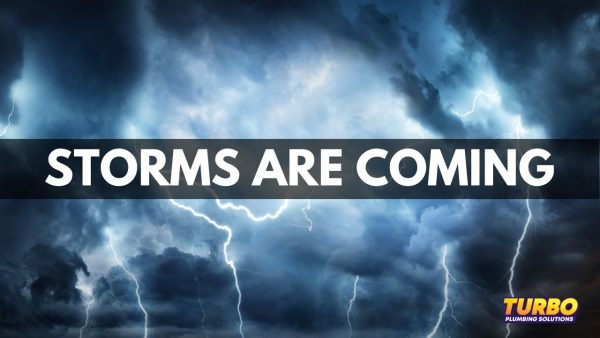 Dark storm clouds and lightning fill the sky with "STORMS ARE COMING" in bold letters across the center; Turbo Plumbing Solutions logo appears in the bottom right, reminding you about plumbing preparation for Brisbane summer storms.